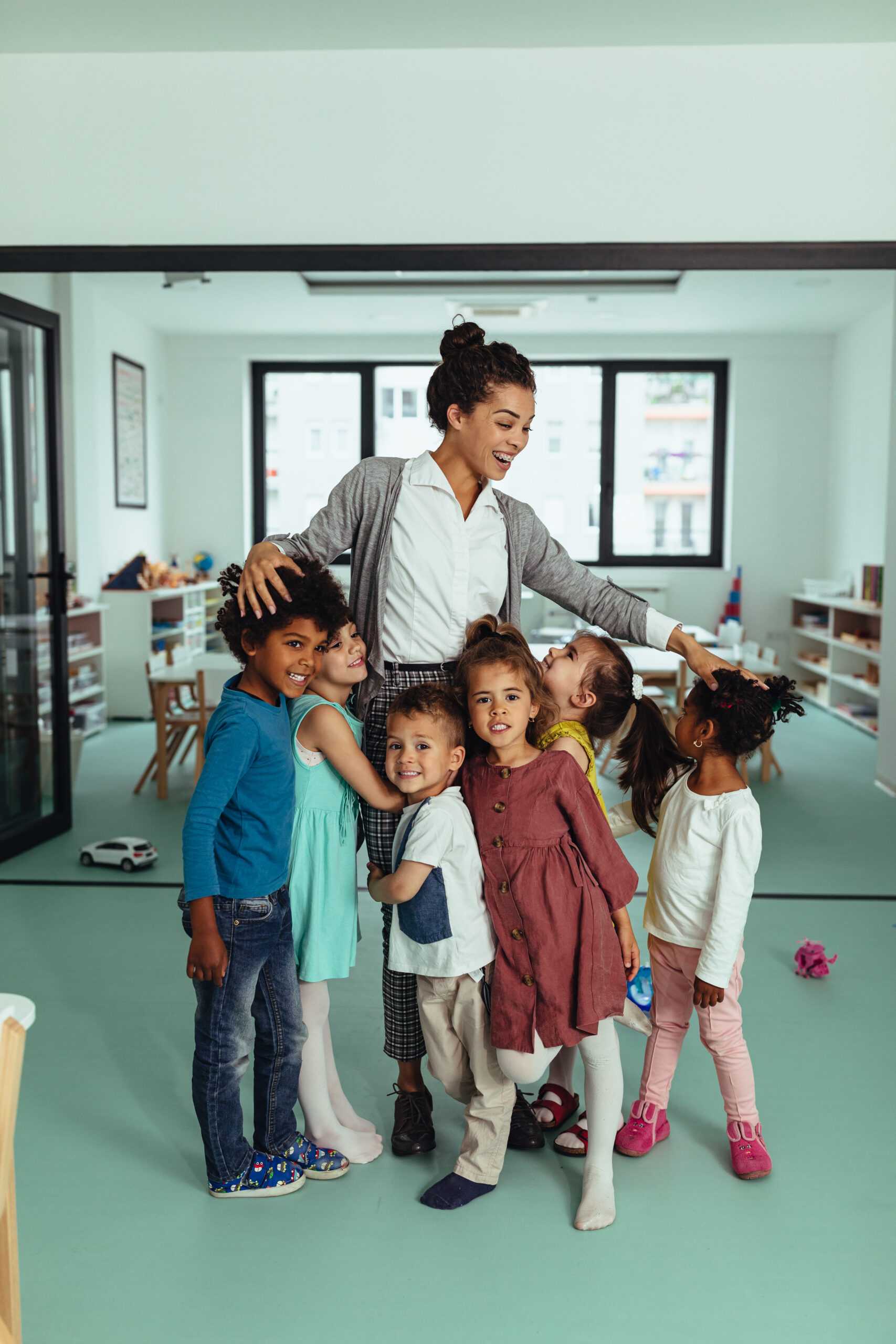 Teacher and little children playing at kindergarten