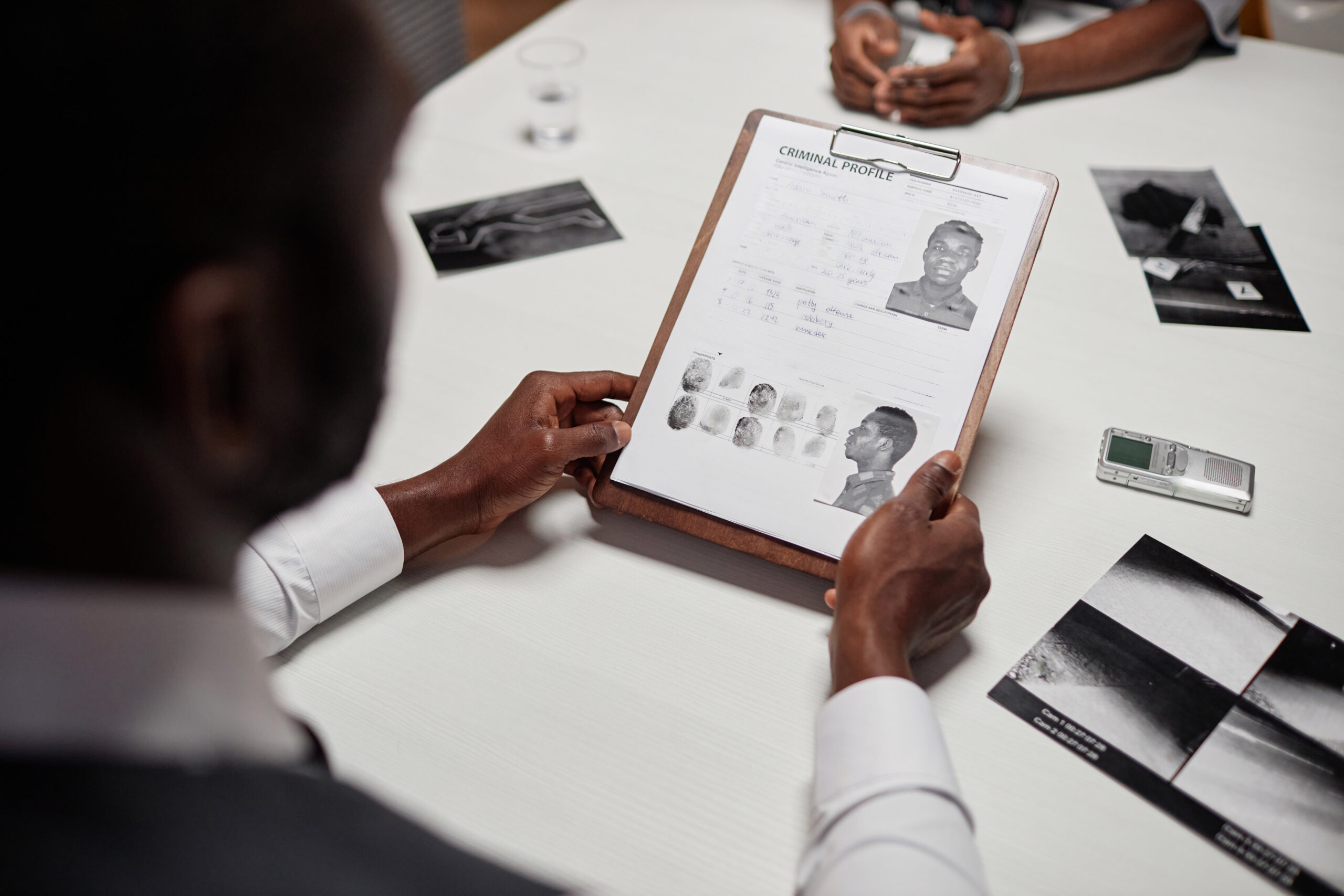 Close up of detective holding suspect personal file while investigating criminal case, copy space