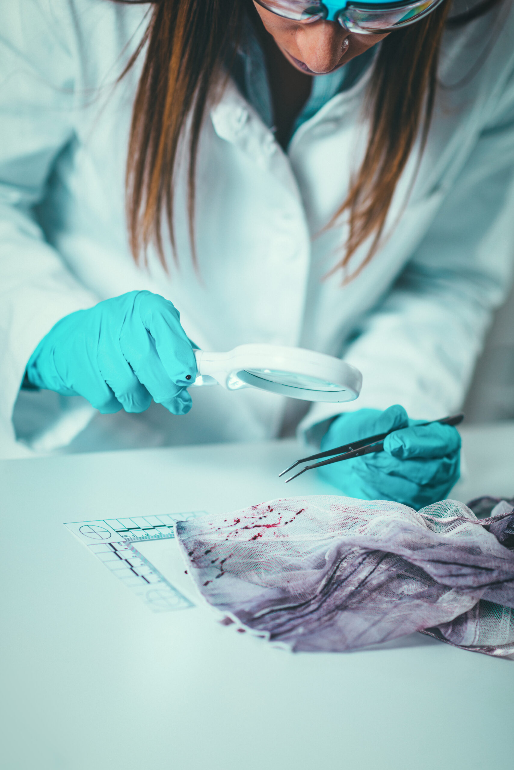 Forensic Science in Lab. Forensic Scientist examining textile with blood evidences