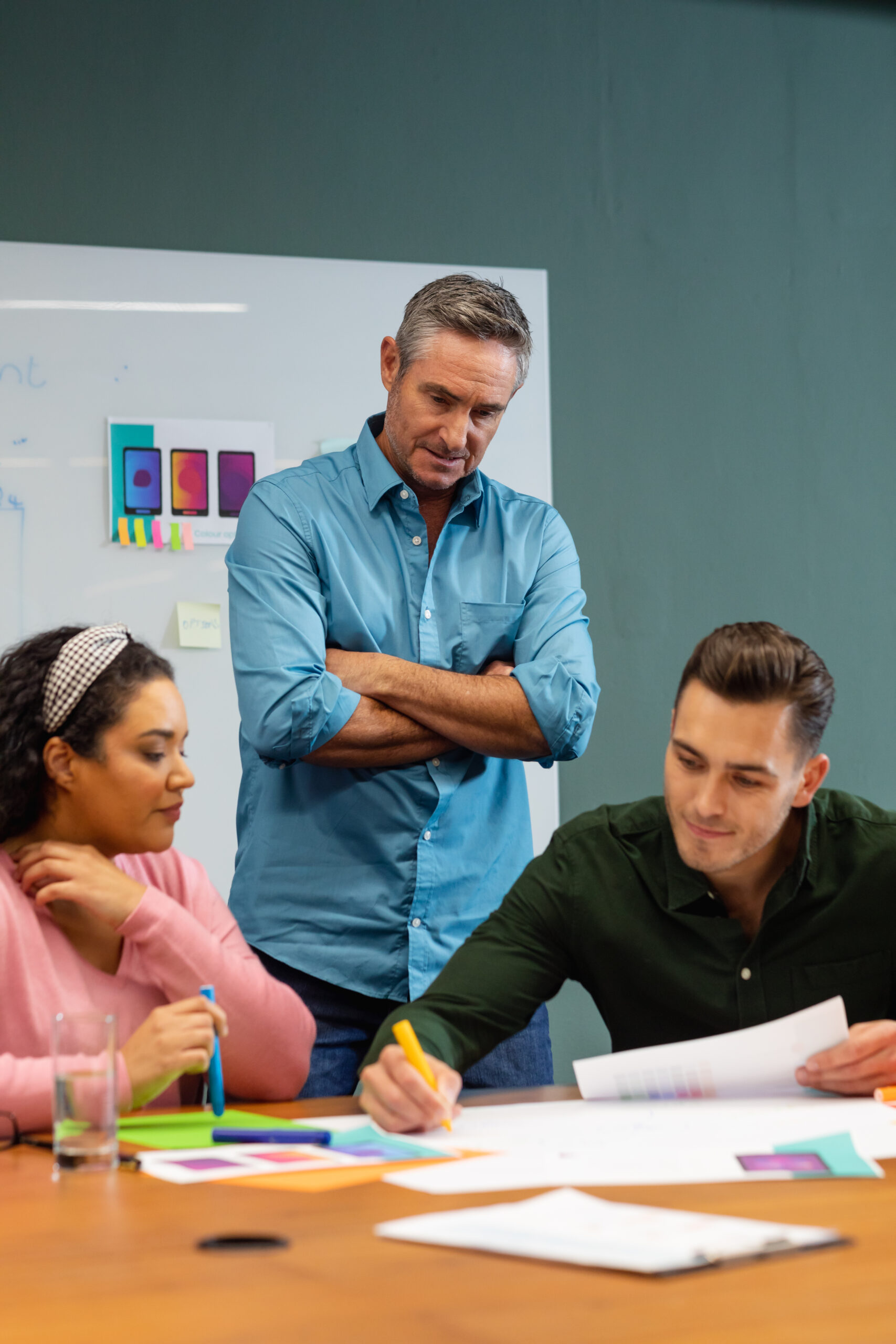 Manager looking at multiracial colleagues discussing business strategy in meeting at creative office. Unaltered, creative business, workplace, discussion, diversity, planning, meeting.