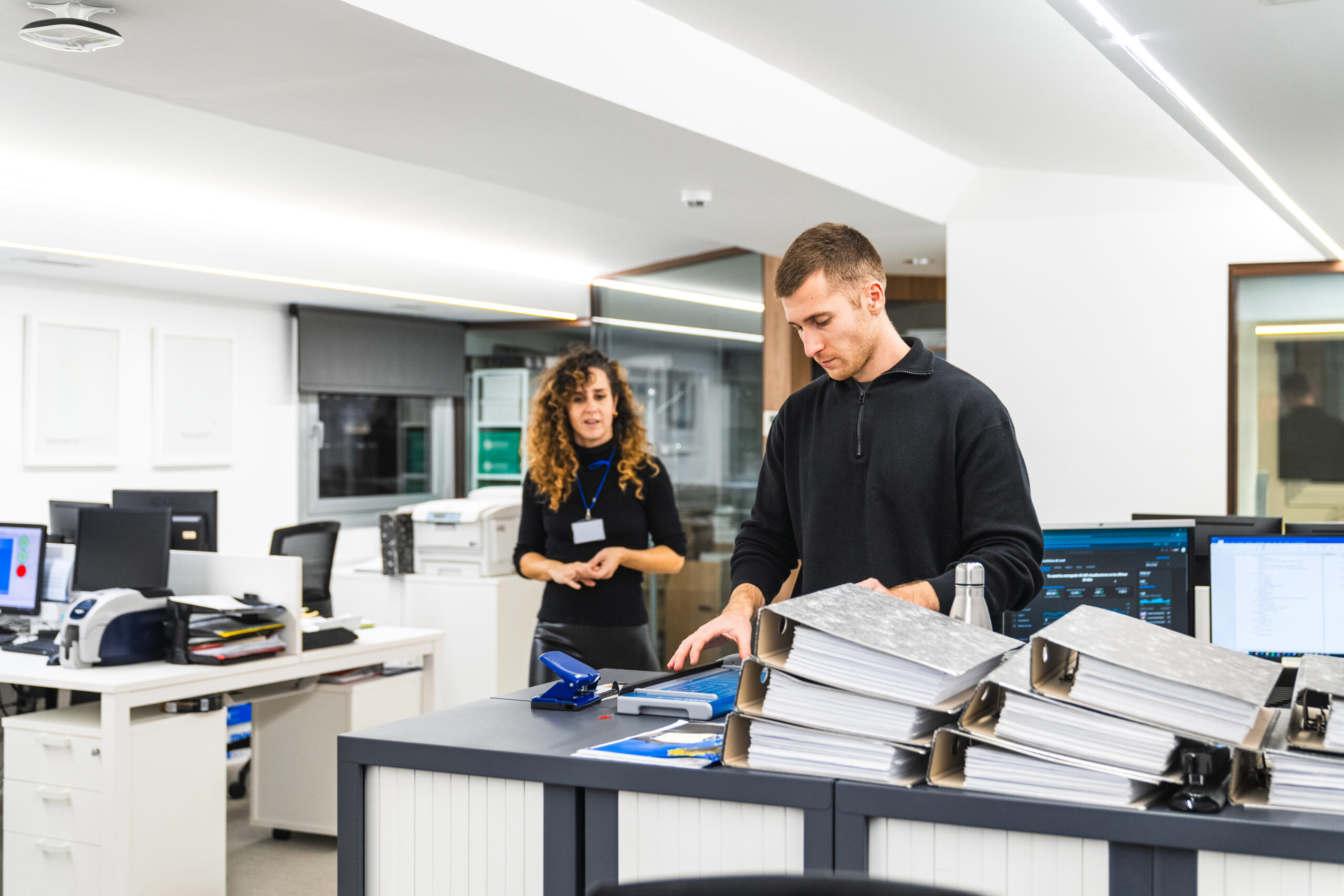 Two professionals in a dynamic conversation at a modern office reception